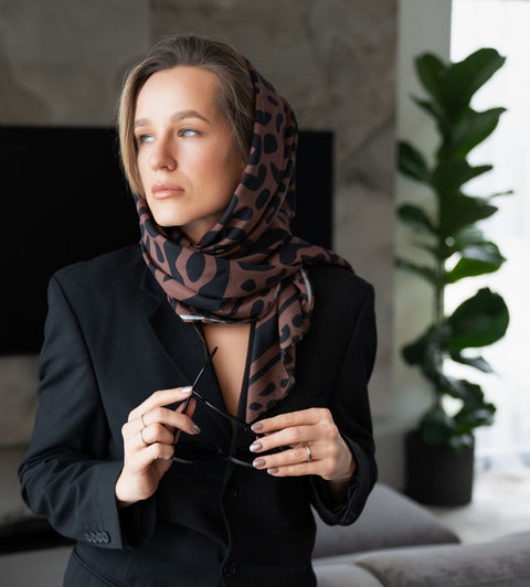 2. Women's Classic Leopard Scarf by Garbanota styled elegantly as a headscarf, paired with a black blazer in a lifestyle setting