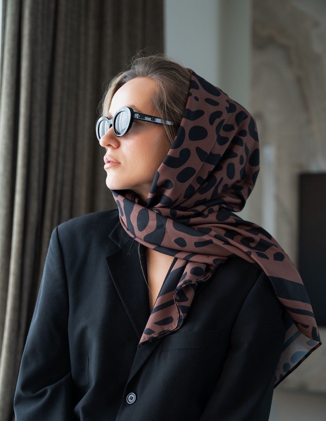 1. Women's Classic Leopard Scarf by Garbanota styled as a headscarf, worn with sunglasses and a black blazer in a lifestyle setting