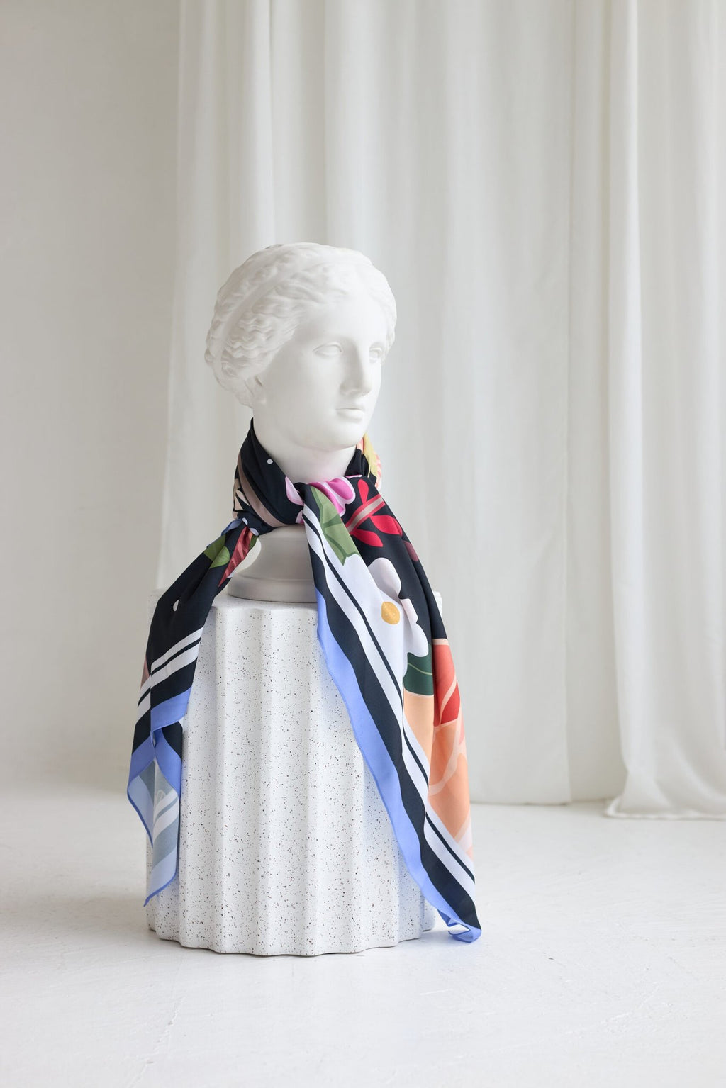 4. Garbanota Scarf Curly Summer Night tied around a mannequin neck, highlighting design