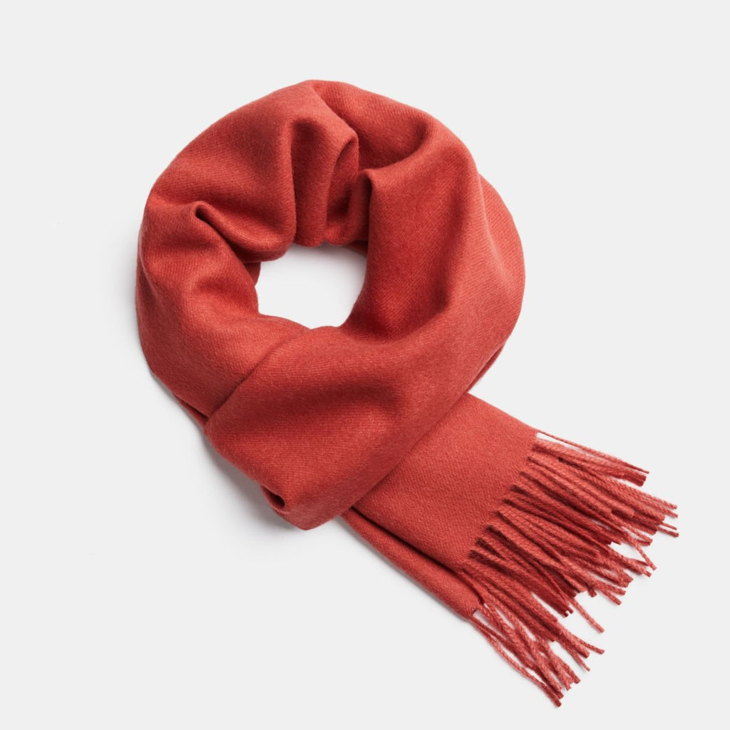 7. Red Alpaka baby alpaca wool scarf with fringe detail in flat lay