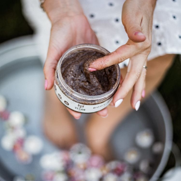 1. Woman using Vegan Fox Coffee Body Scrub, showing texture and application on skin