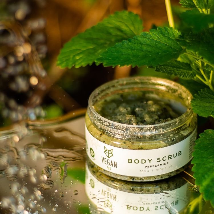 6. Vegan Fox Peppermint Body Scrub jar in natural setting with peppermint leaves