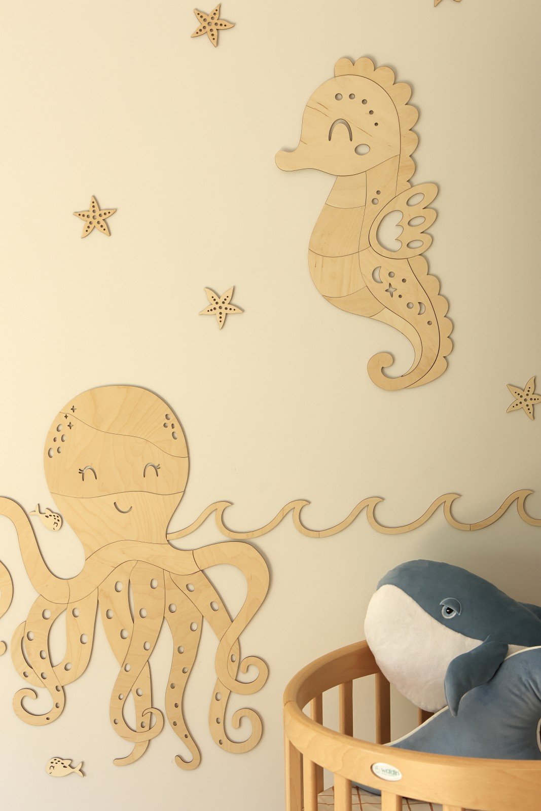 2. Wooden seahorse and octopus wall decorations in natural plywood with starfish accents in a nursery