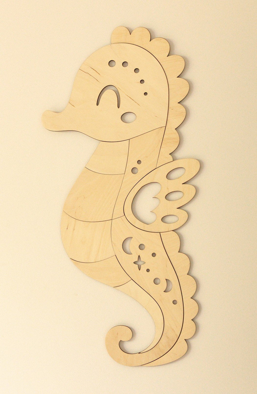 2. Wooden seahorse wall decoration in natural plywood with detailed cutouts on a plain wall