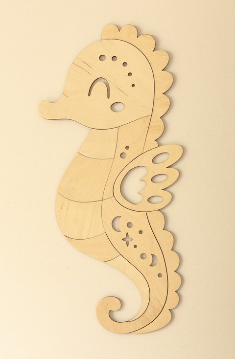 2. Wooden seahorse wall decoration in natural plywood with detailed cutouts on a plain wall