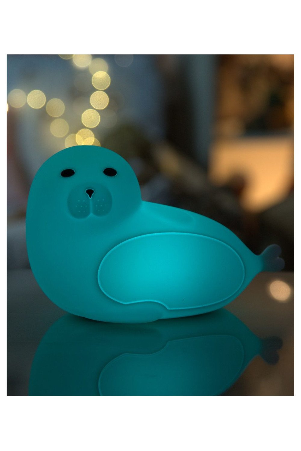 3. Blue glowing seal-shaped lamp in dark room with bokeh lights