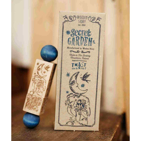2. Secret Garden puzzle block with blue ends next to branded packaging on wooden surface