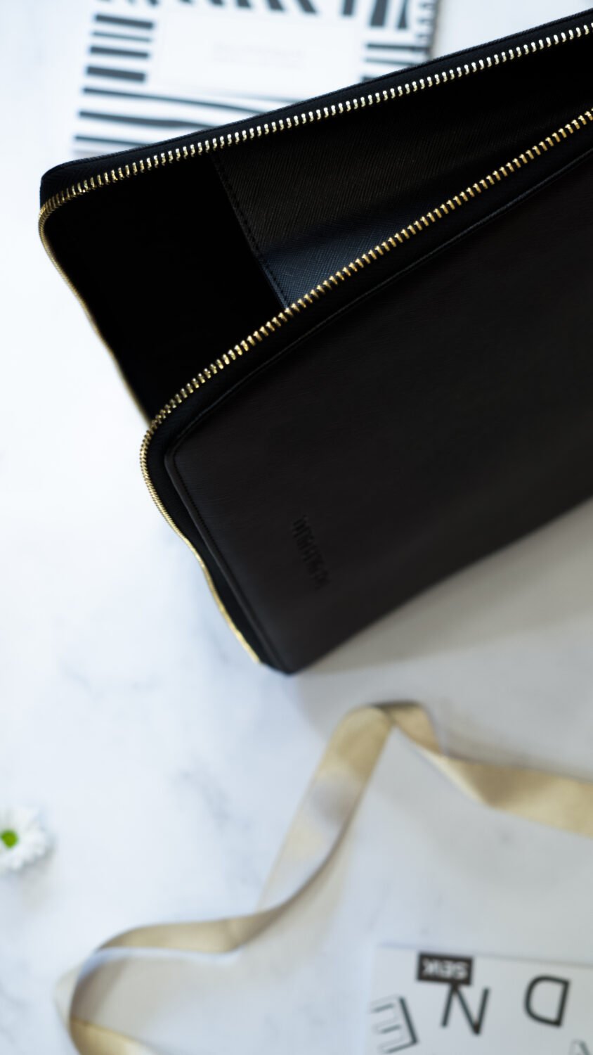 2. Close-up of SEIK Dream.Plan.Do laptop sleeve with open zipper, highlighting interior and faux leather material