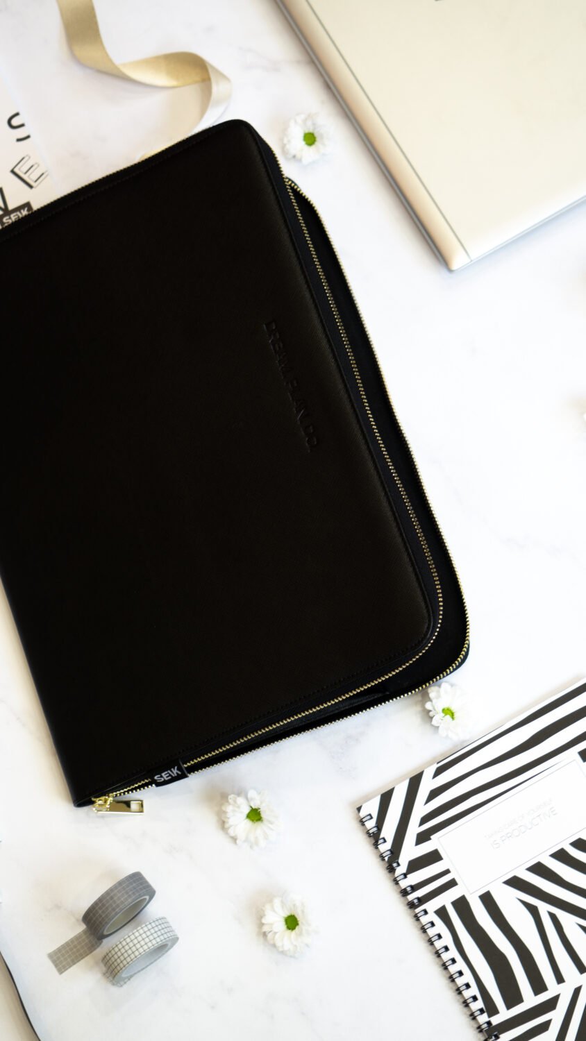 5. SEIK Dream.Plan.Do laptop sleeve on marble surface with accessories, showing sleek design and motivational embossing