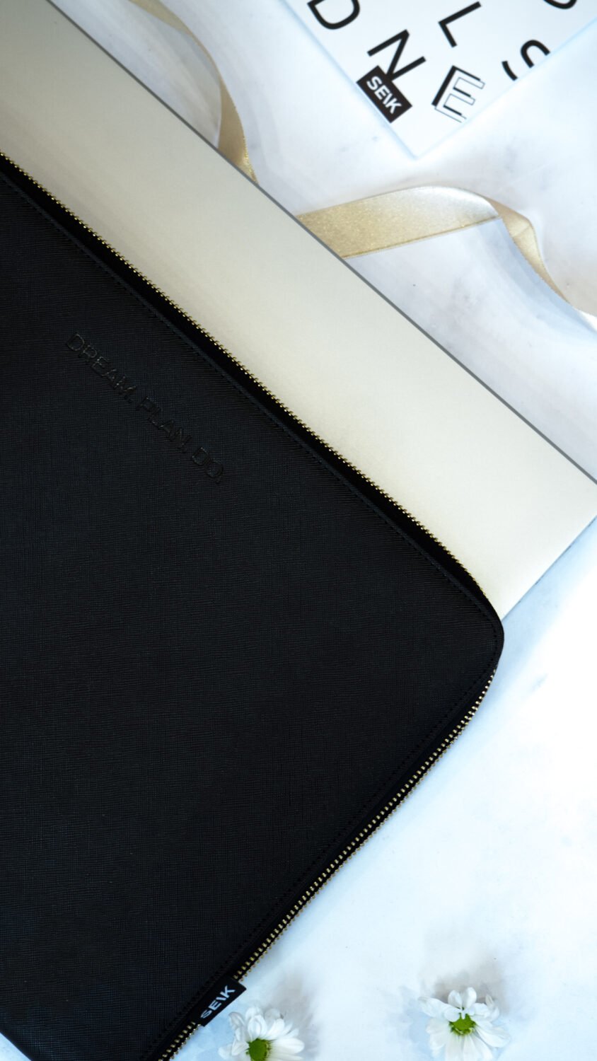 6. SEIK Dream.Plan.Do laptop sleeve with laptop partially inserted, highlighting protective fit and faux leather texture