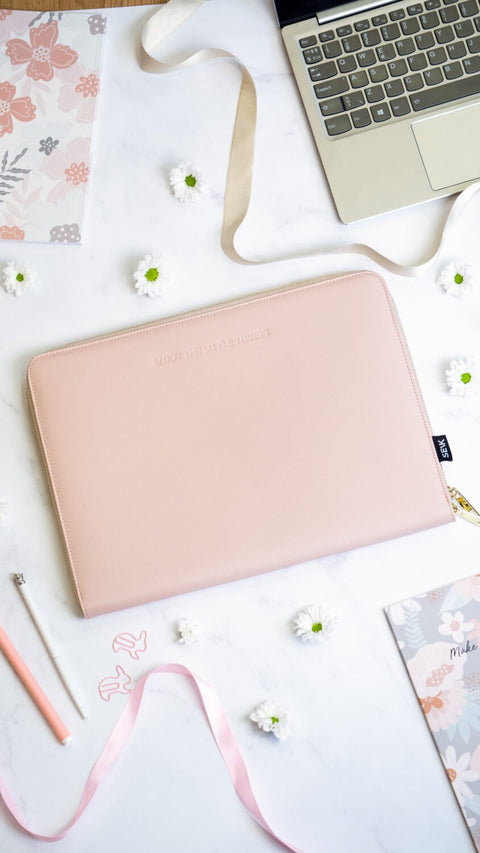 1. SEIK pink laptop sleeve on a desk with floral decor, showcasing minimalist design
