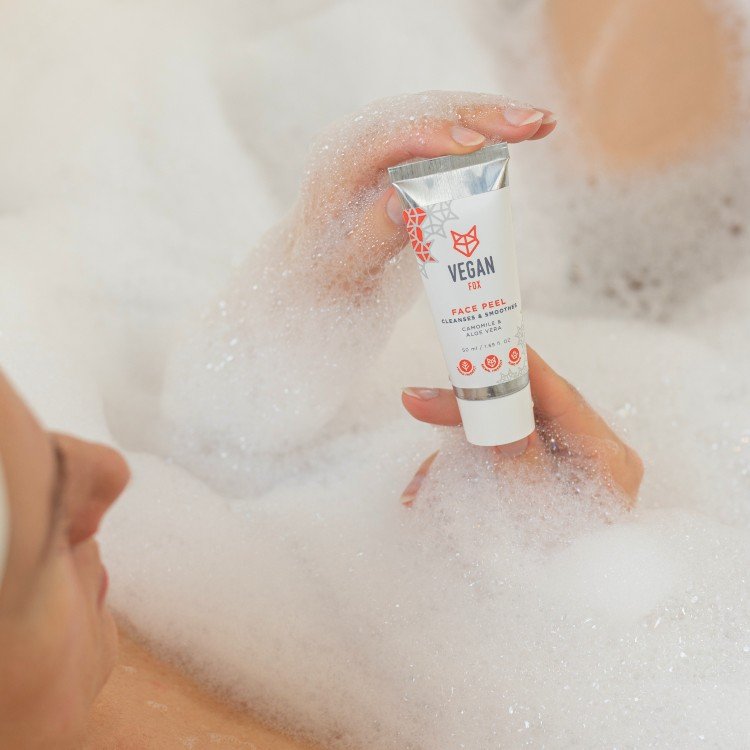 1. Vegan Fox Face Peel held by a woman in a bubble bath, showcasing its gentle cleansing properties