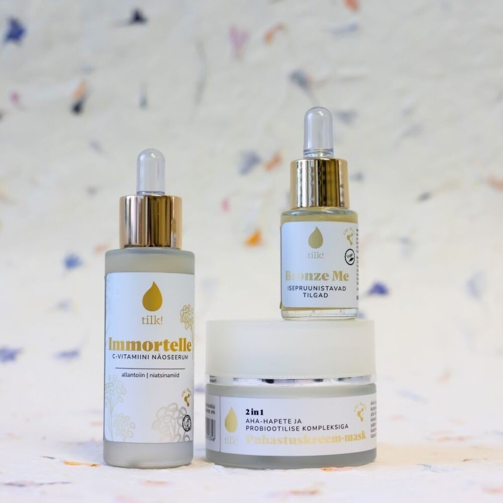 3. Tilk! Self-Tanning Drops alongside Immortelle serum and 2in1 mask, arranged in a studio setting
