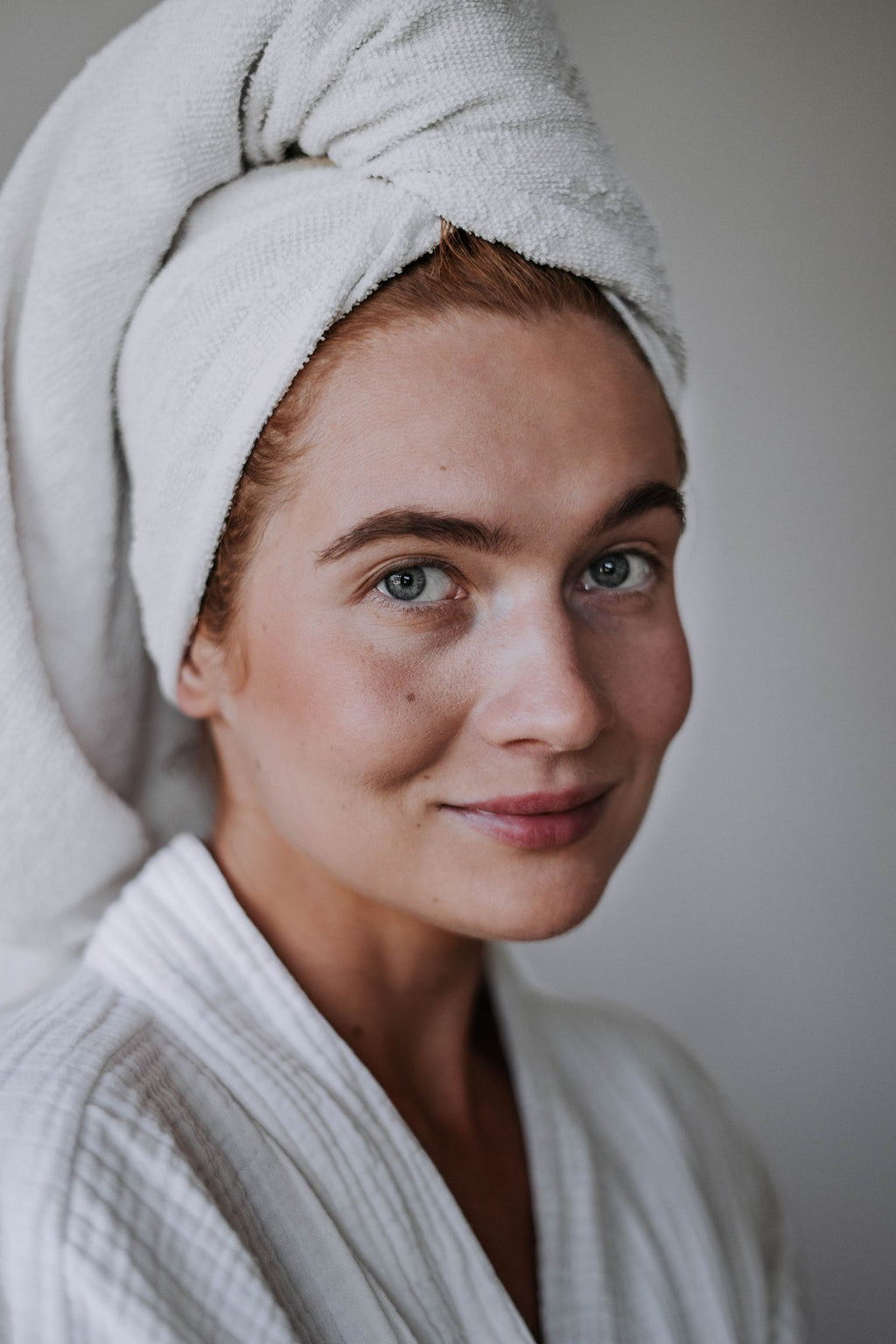 9. Woman with towel on head, showing natural glow after using LUUV Self-Tanning Face Serum