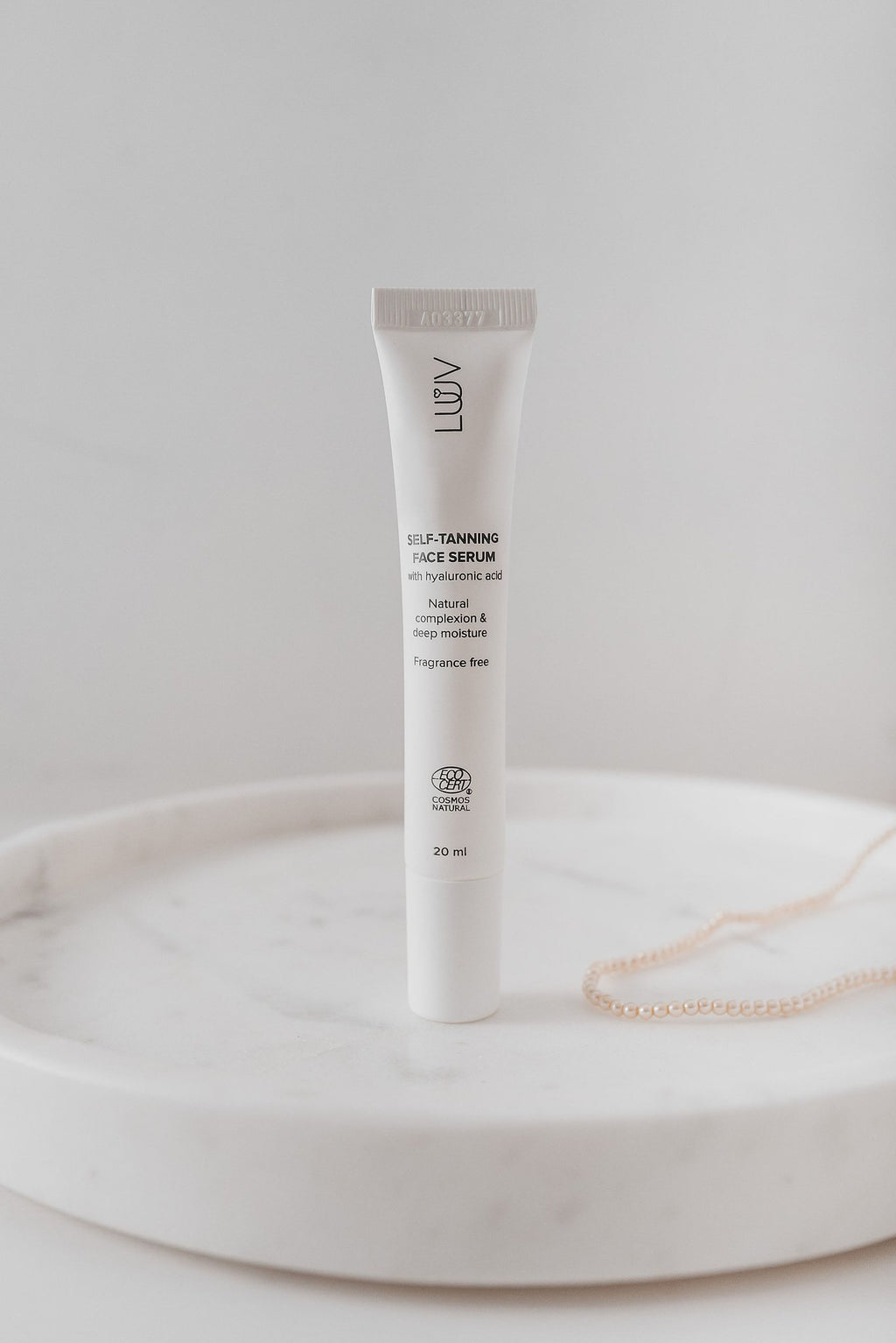 8. LUUV Self-Tanning Face Serum tube on marble surface, highlighting product design