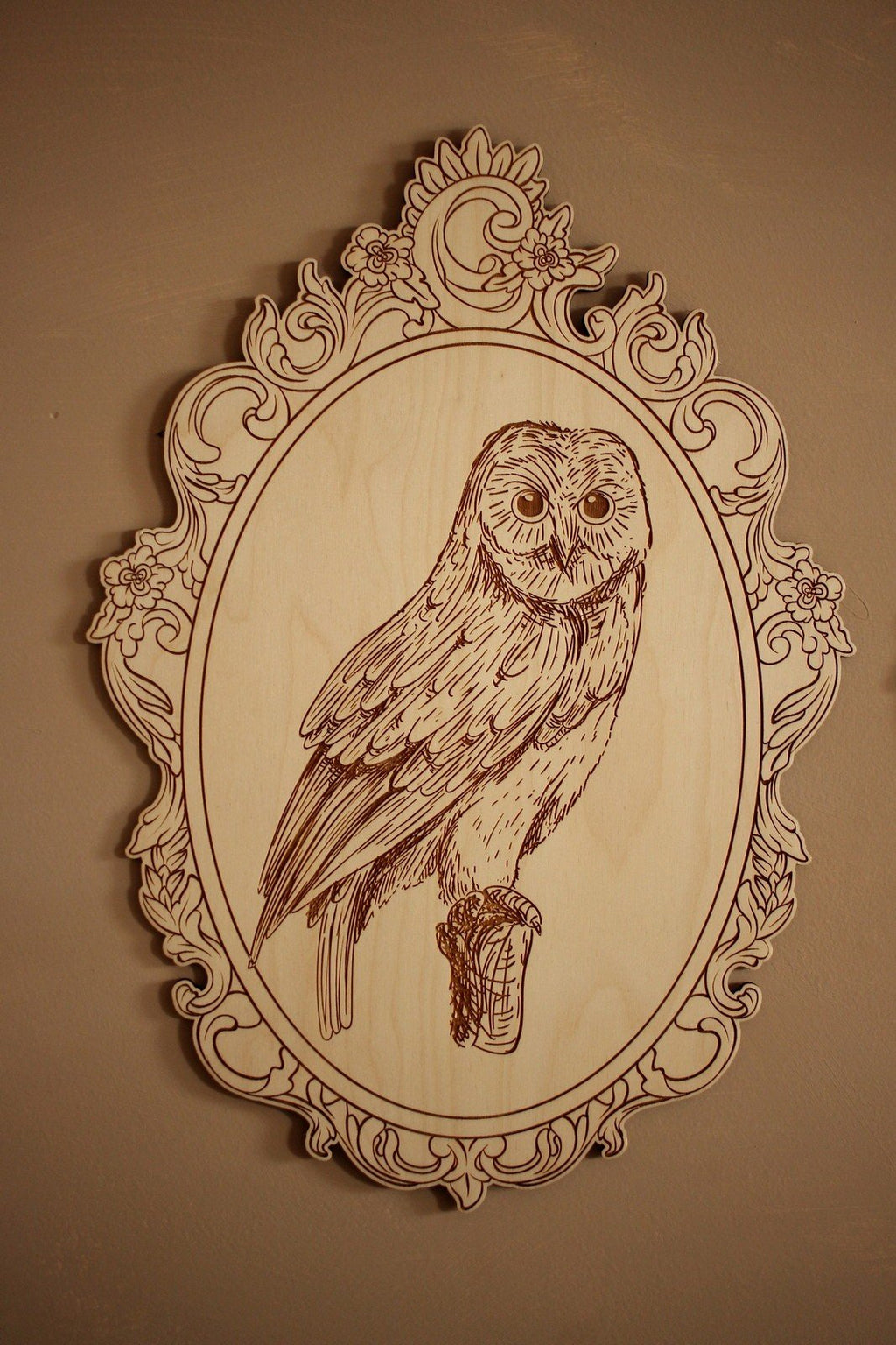6. Close-up of engraved owl picture in ornate retro frame on wall