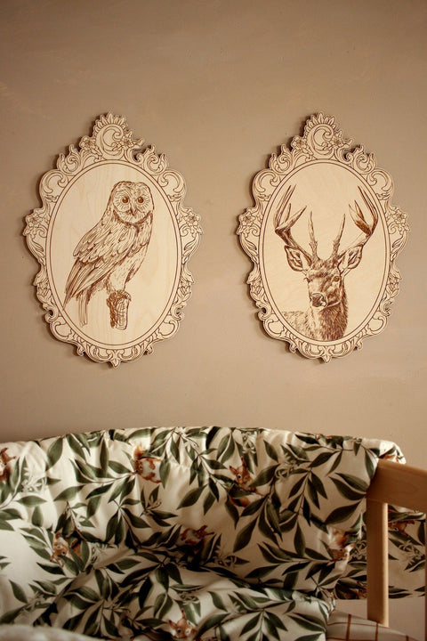 1. Engraved owl and deer pictures in retro frames on wall above floral-patterned couch