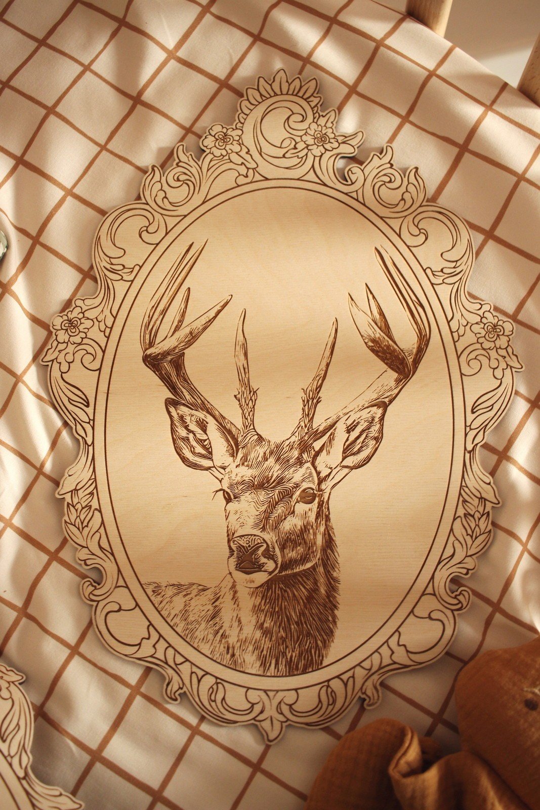 11. Engraved deer picture in retro frame on checkered fabric with floral pattern