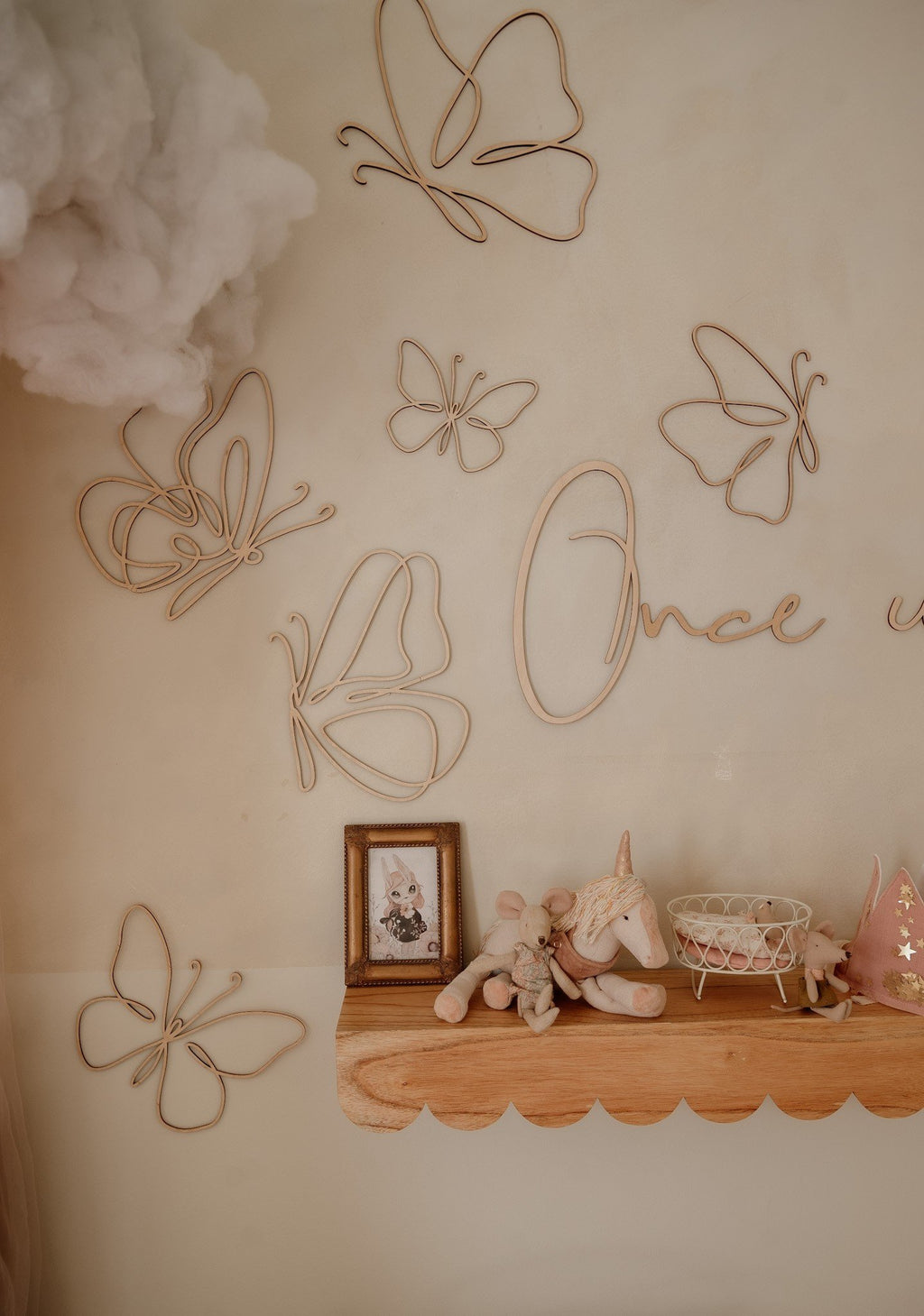 2. Wooden butterfly wall decorations in a child's room with a shelf, toys, and a cloud decor, adding a whimsical touch.