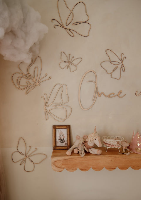 2. Wooden butterfly wall decorations in a child's room with a shelf, toys, and a cloud decor, adding a whimsical touch.