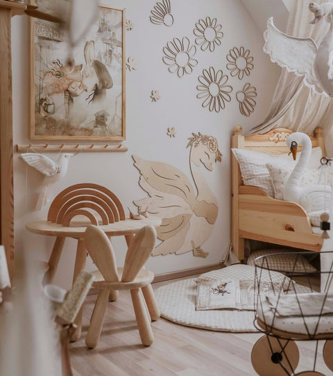 3. Child's room with natural plywood daisy wall decorations, wooden furniture, and a swan-themed bed, creating a whimsical and organic decor.
