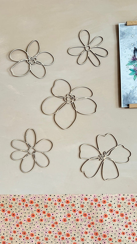 1. Set of six natural plywood flower wall decorations arranged on a beige wall, showcasing different sizes and shapes, adding a natural touch to the room.