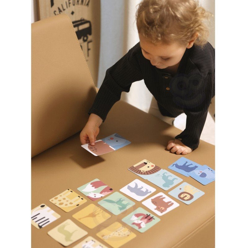5. Child arranging animal picture cards from Shaky Tower game on a brown surface