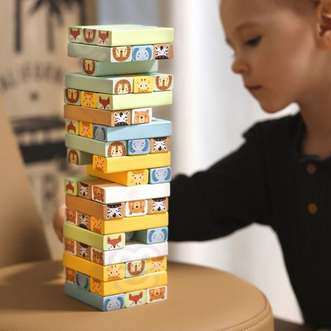 4. Child playing with Shaky Tower game, stacking colorful animal blocks on a round cushion