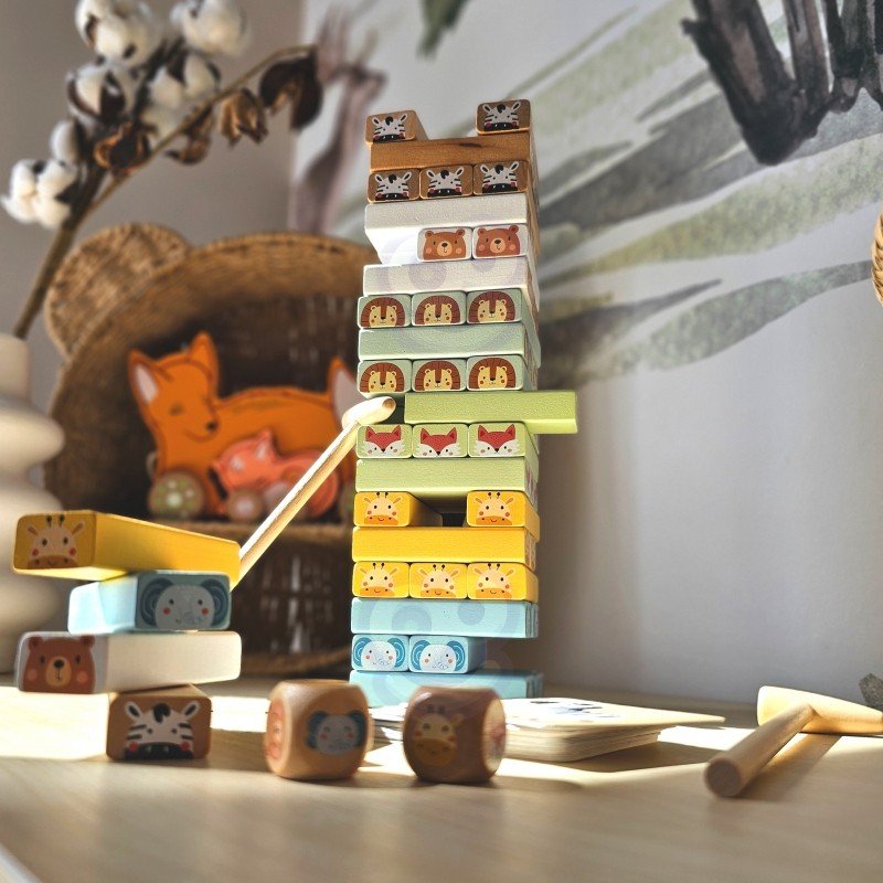1. Shaky Tower skill game with pastel-colored wooden blocks and animal designs on a table with a cozy background