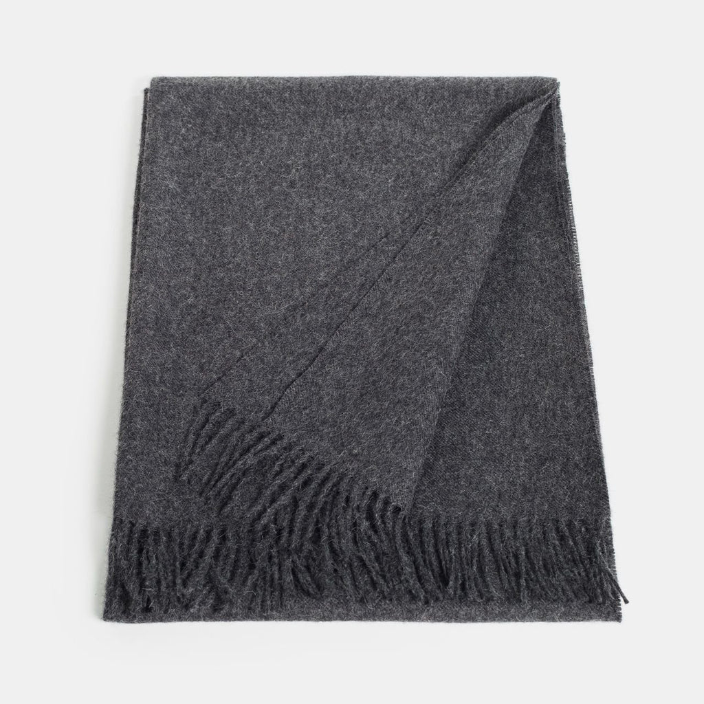 23. Flat lay of Alpaka natural baby alpaca maxi-scarf in dark grey with fringes, showing full length