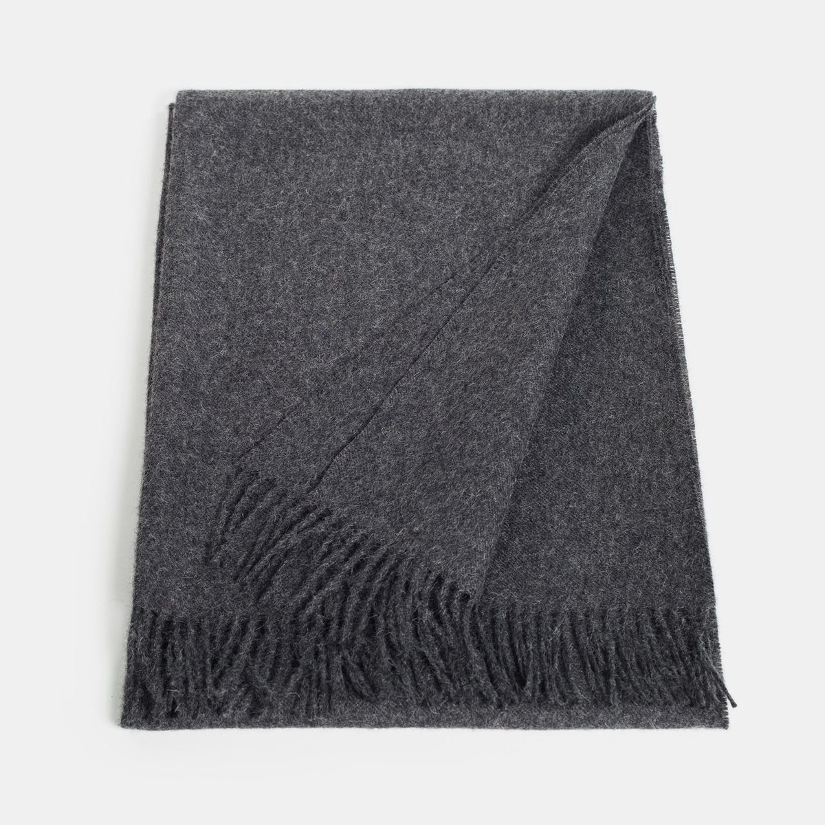 23. Flat lay of Alpaka natural baby alpaca maxi-scarf in dark grey with fringes, showing full length