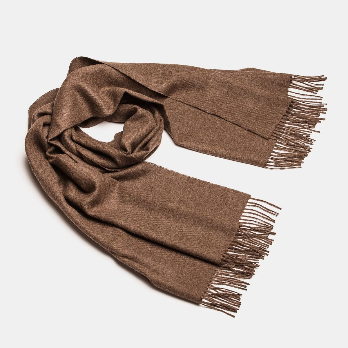 7. Studio shot of Alpaka natural baby alpaca maxi-scarf in brown with fringes, displayed in a rolled style