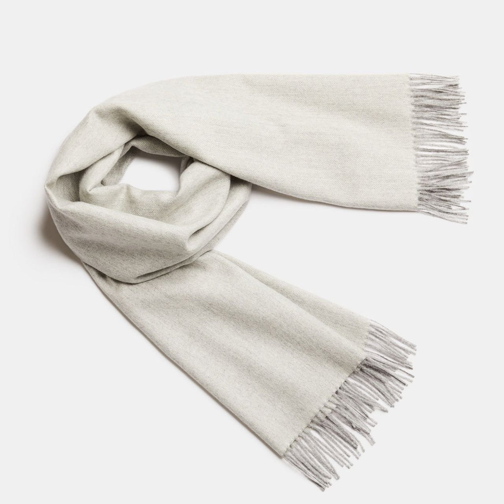3. Studio shot of Alpaka natural baby alpaca maxi-scarf in beige with fringes, displayed in a rolled style