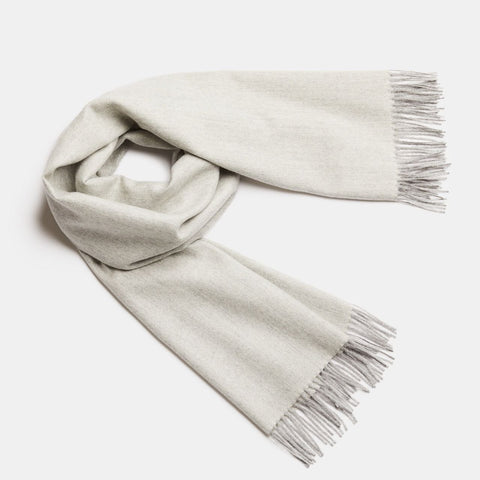 3. Studio shot of Alpaka natural baby alpaca maxi-scarf in beige with fringes, displayed in a rolled style