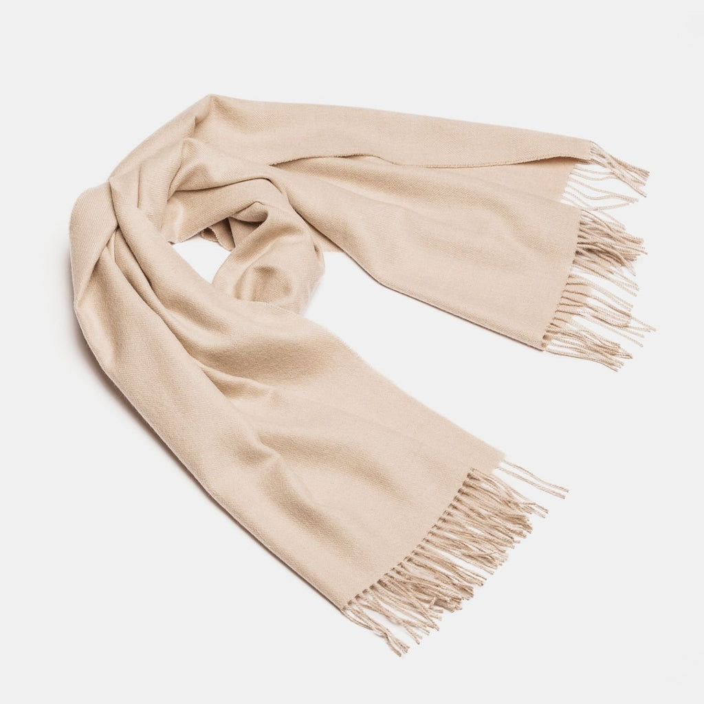 19. Studio shot of Alpaka natural baby alpaca maxi-scarf in beige with fringes, displayed in a rolled style