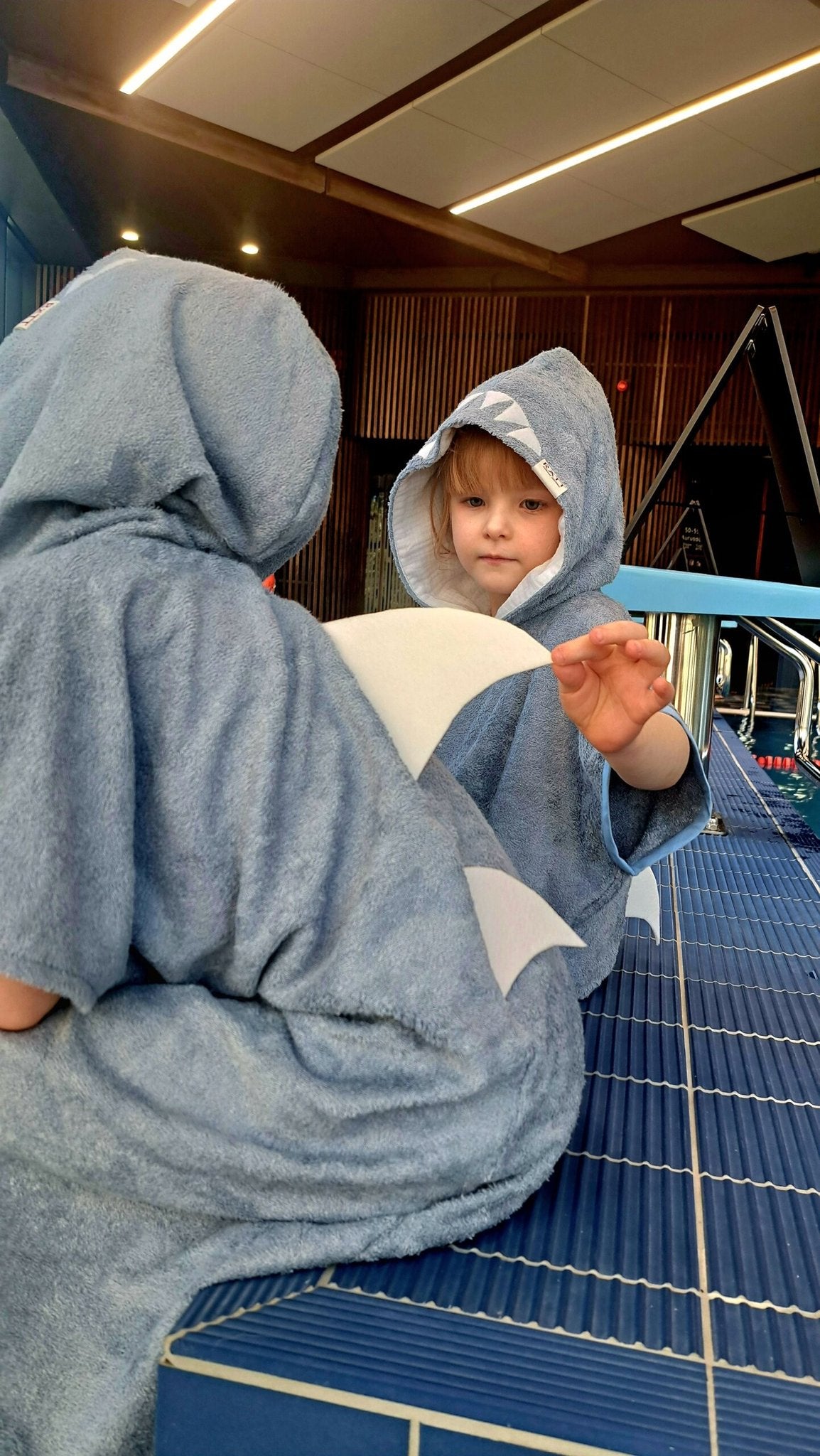 3. Close-up of children in RÄTT Short-Sleeve Poncho SHARK, showing playful shark fin detail