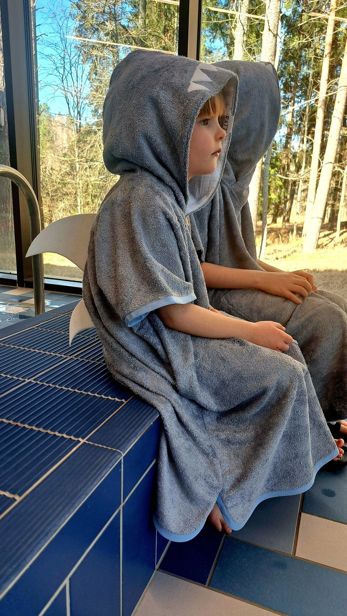 2. Two children sitting by the pool in RÄTT Short-Sleeve Poncho SHARK, highlighting shark fin design