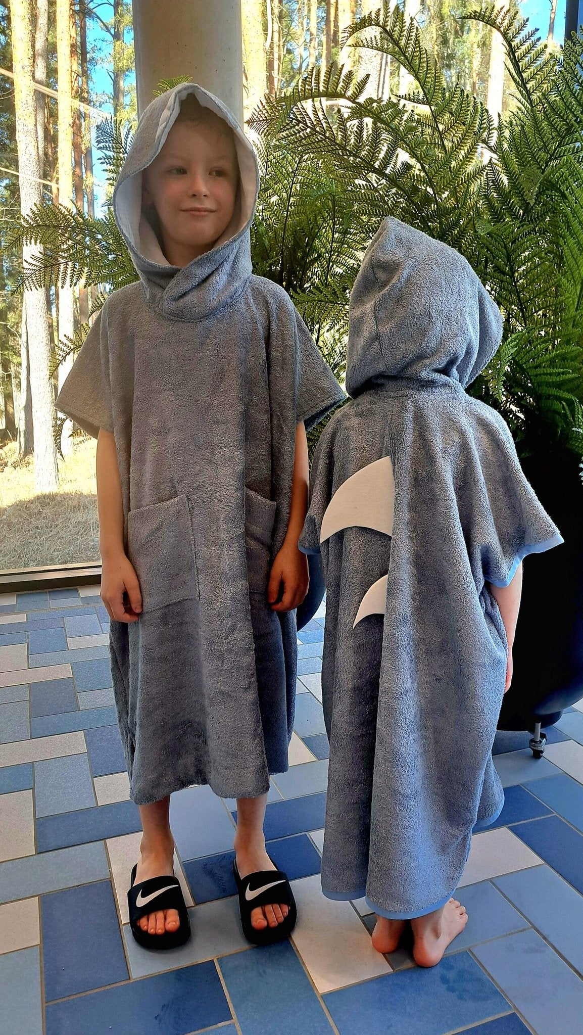 2. Two toddlers in RÄTT Short-Sleeve Poncho SHARK, front and back view, lifestyle setting