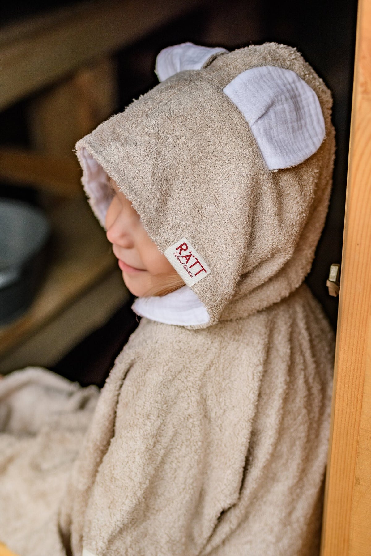 4. Close-up of RÄTT short-sleeve poncho TEDDY hood with ears, worn by toddler