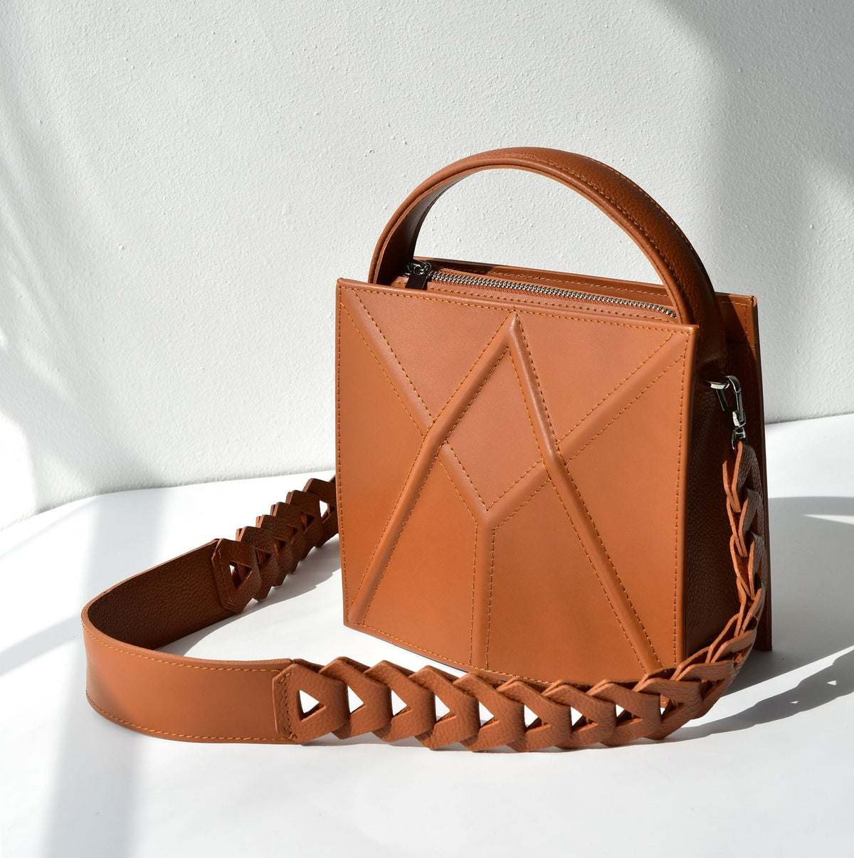 7. Caramel brown FACET shoulder bag by Gerda Retter Design, displayed in a bright studio setting