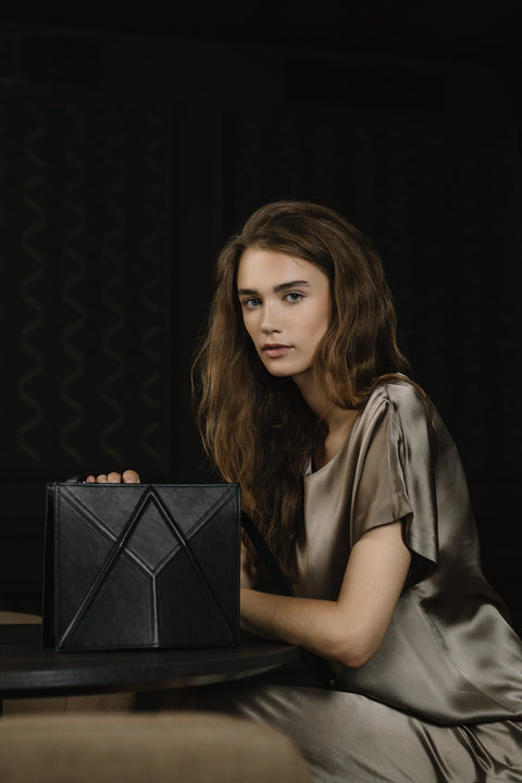 2. Women's black FACET shoulder bag by Gerda Retter Design, showcased in a dark studio setting