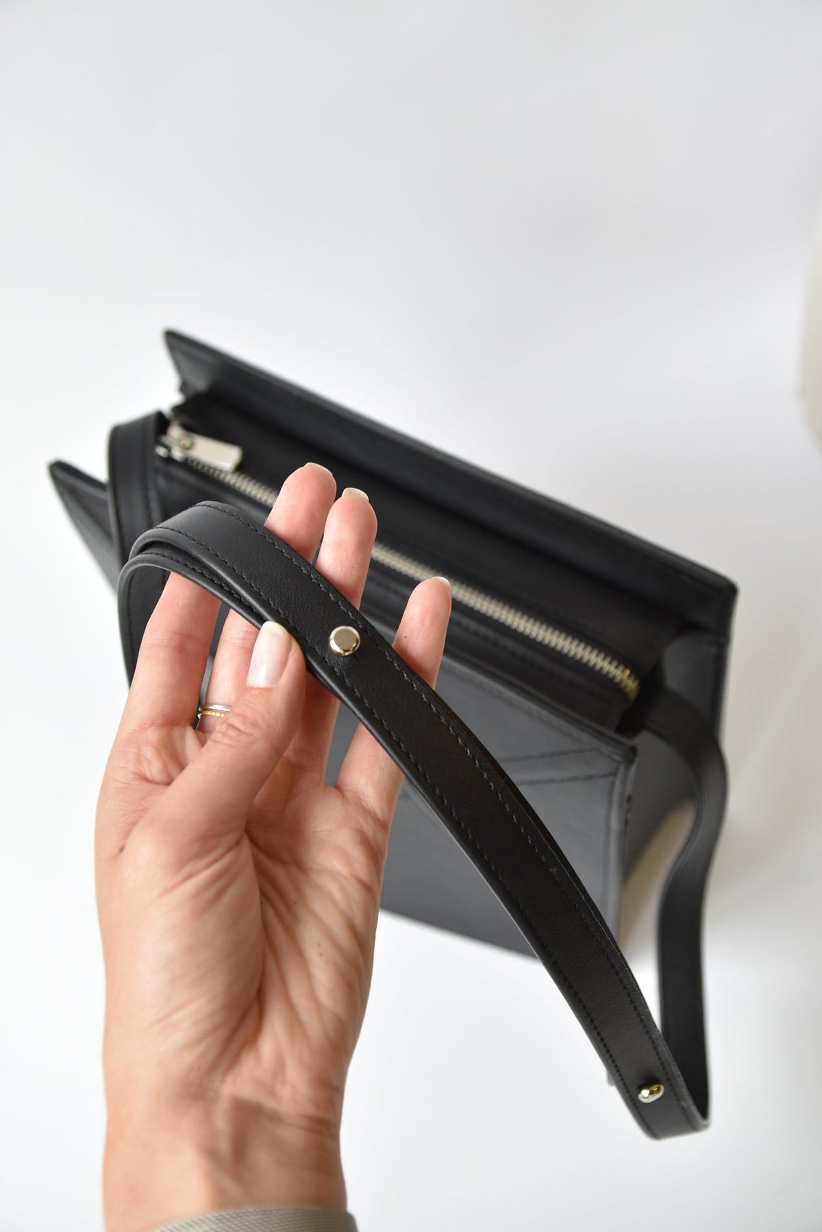 12. Close-up of black FACET shoulder bag by Gerda Retter Design, highlighting the handle and strap