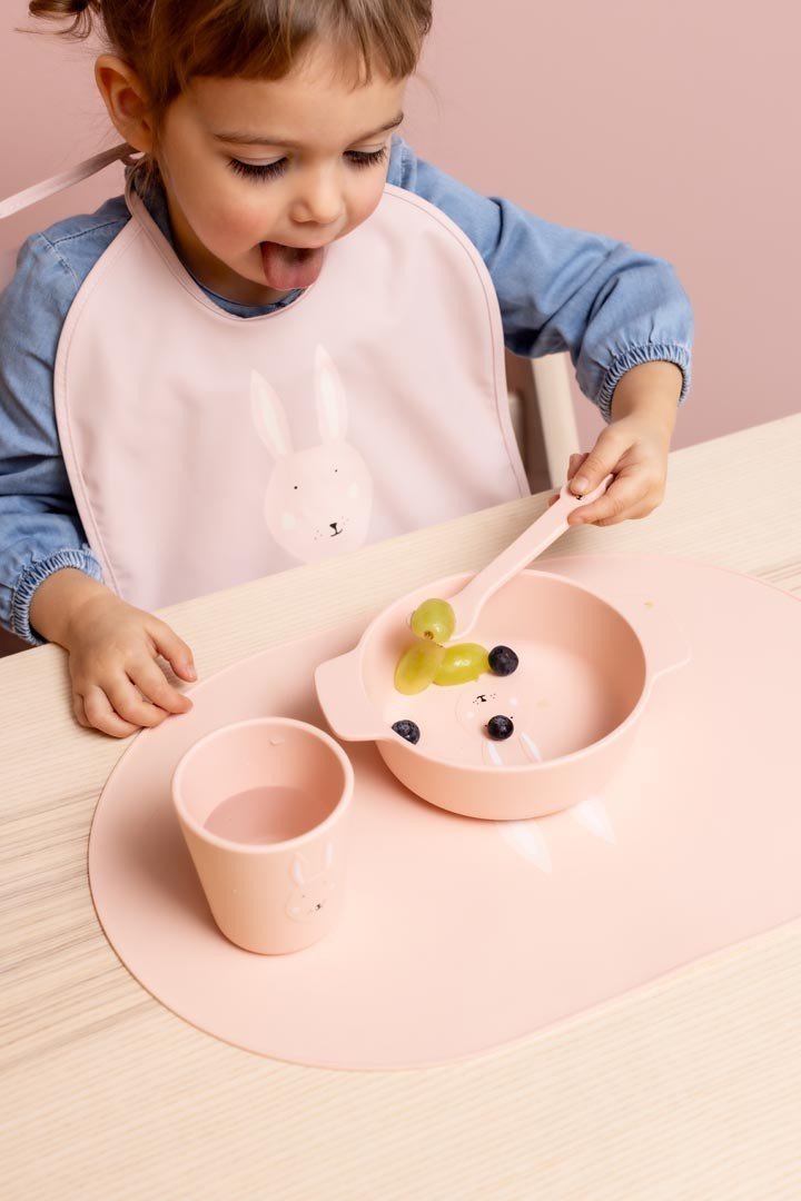 4. Child eating with pink Trixie Baby Mrs. Rabbit silicone bowl and cup set