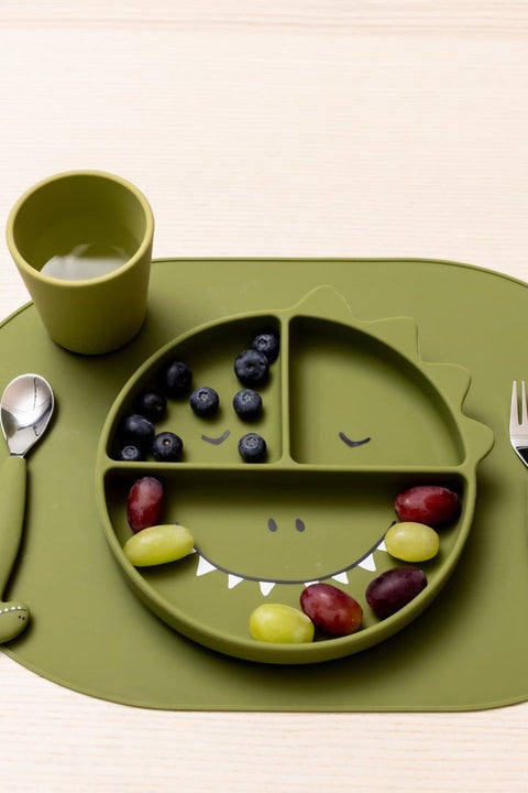 1. Green silicone cup with dinosaur design on dining table with matching plate and cutlery