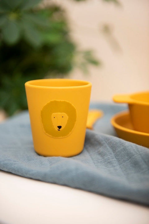 3. Close-up of orange silicone cup with lion face design on blue cloth