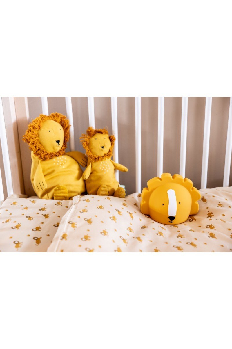 6. Trixie Baby's Mr. Lion silicone night light on a crib mattress with lion-themed plush toys