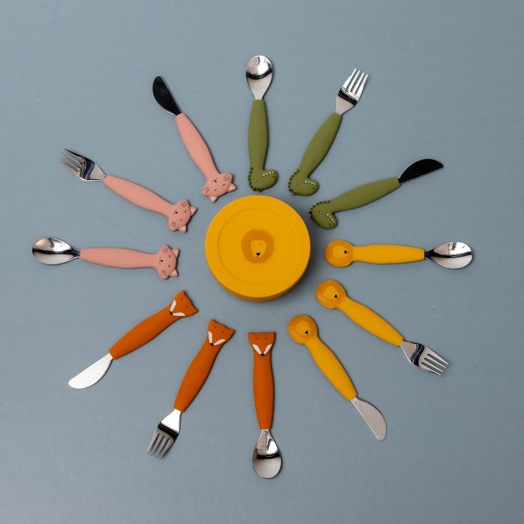 6. Yellow silicone snack container with Mr. Lion face surrounded by colorful children's cutlery