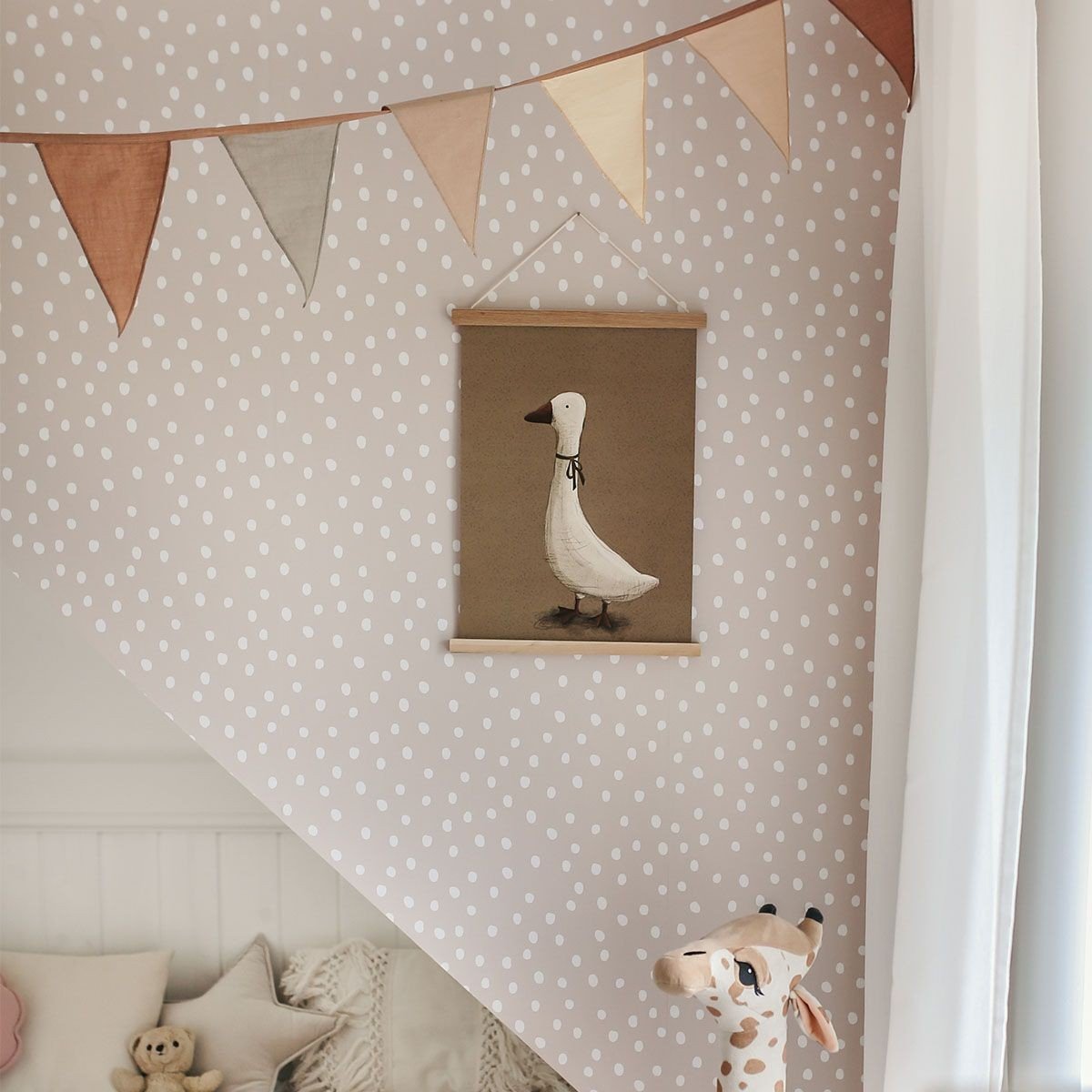 1. Powder pink and white dotted wallpaper in a child's room with bunting and a goose illustration