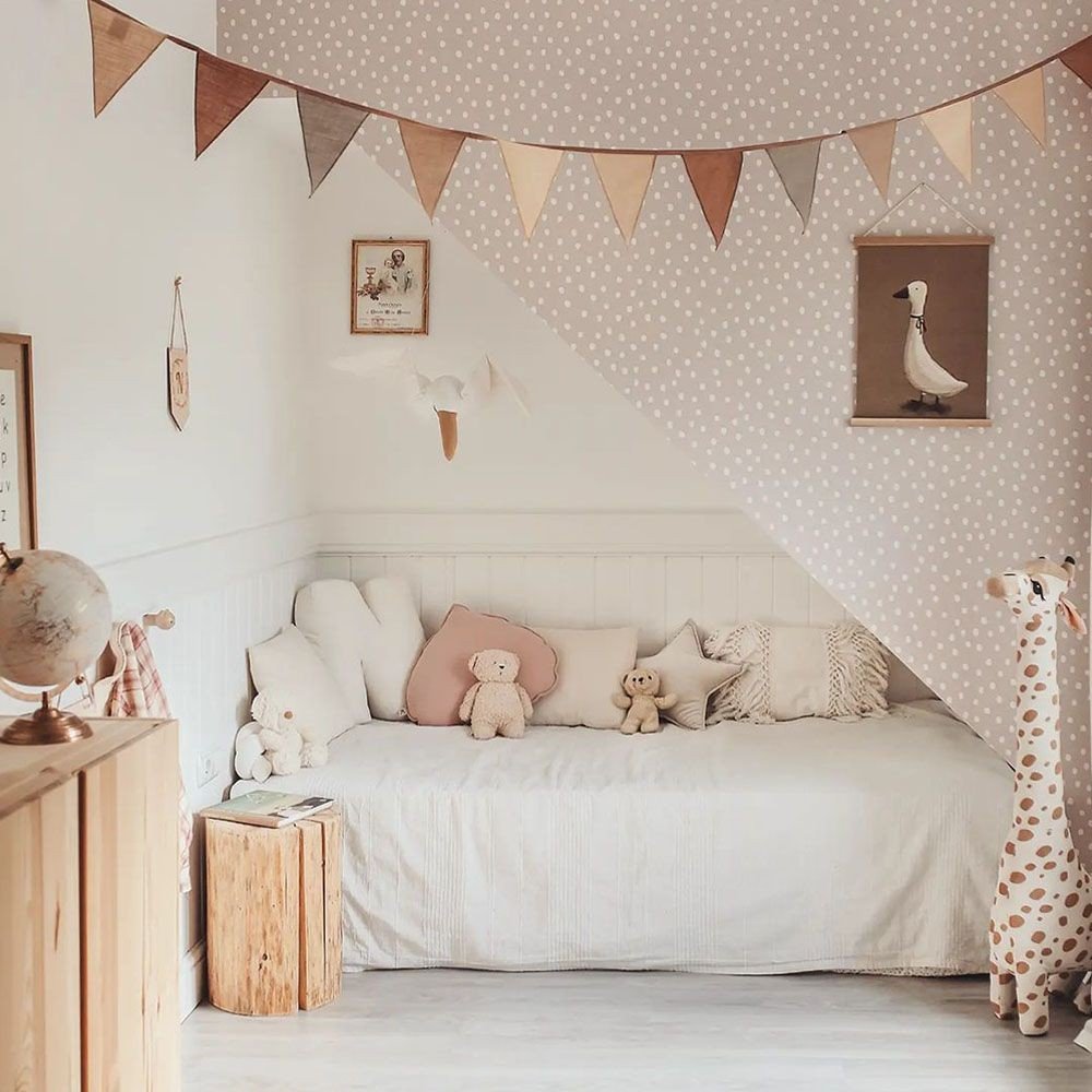 1. Powder pink and white dotted wallpaper in a cozy children's room with bunting and plush toys