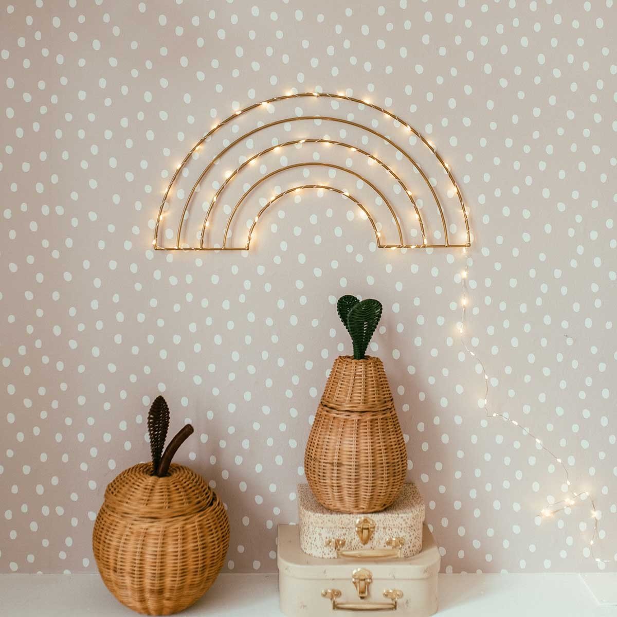 1. Powder pink and white dotted wallpaper in a room with wicker baskets and a lit rainbow decoration